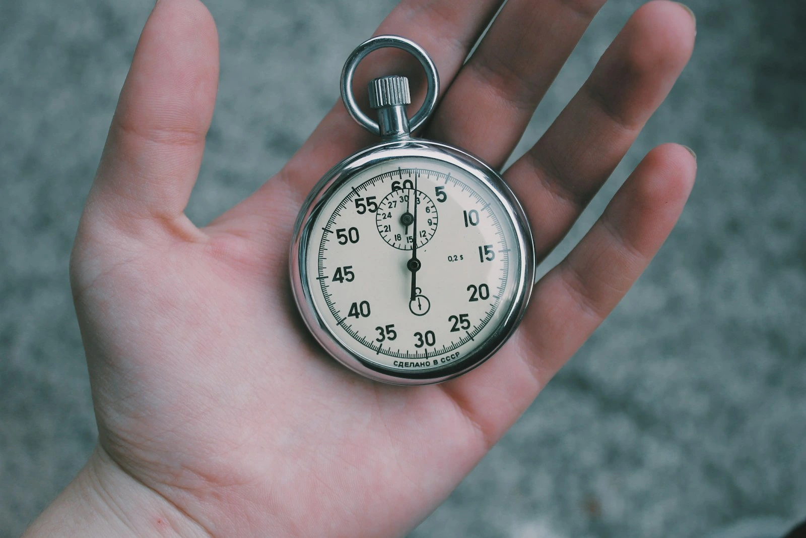 a hand holding a small circular device with a number on it.