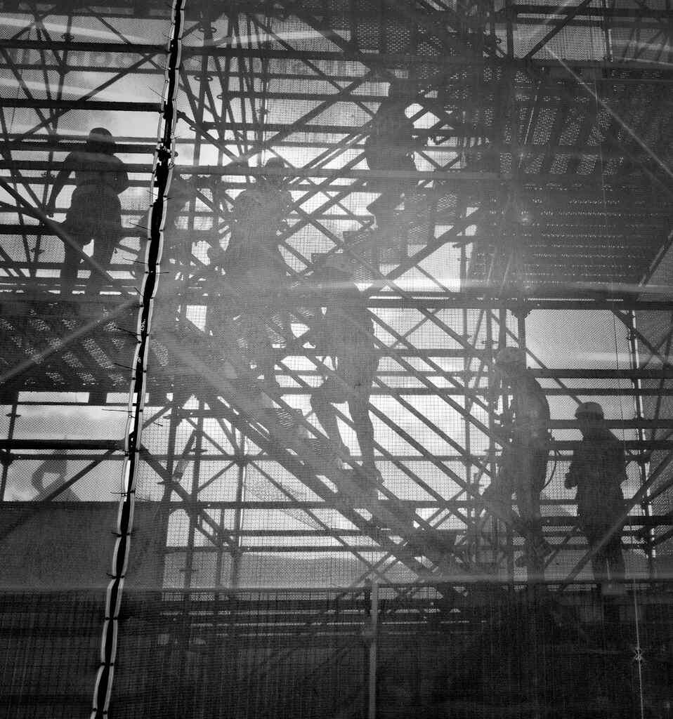 a man is standing on a ledge with a ladder.